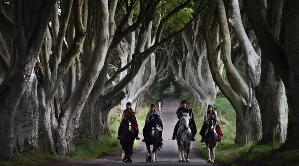 Four actors on horseback dressed in Game of Thrones related costumes carry the Queen's Baton as they make their way way along the Dark Hedges on August 29, 2017 in Antrim, Northern Ireland.