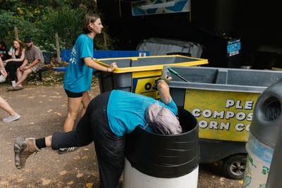 A person dives into a trash can