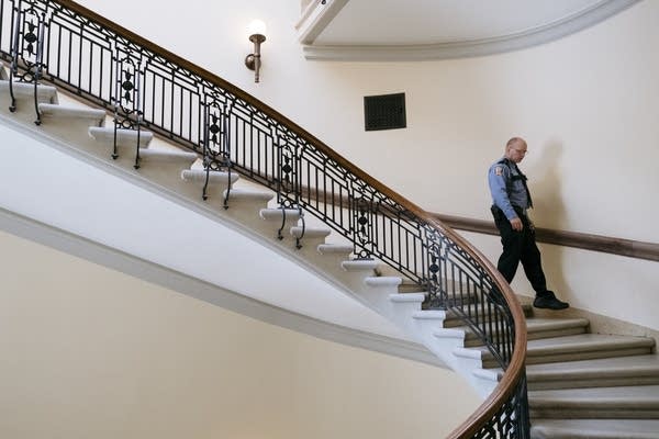 A police officer descends a spiral staircase.