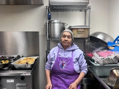 A woman sits in a kitchen.