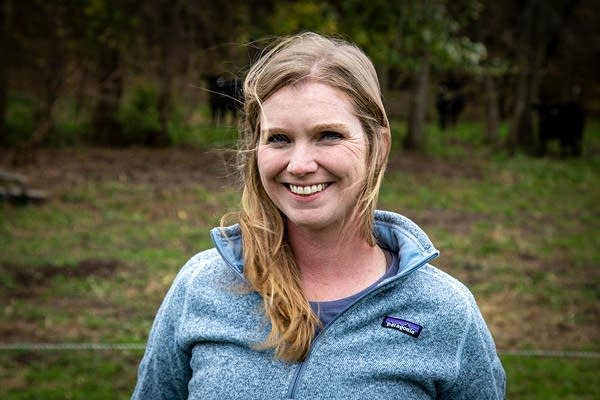 Portrait of a blonde woman in a blue fleece standing outside