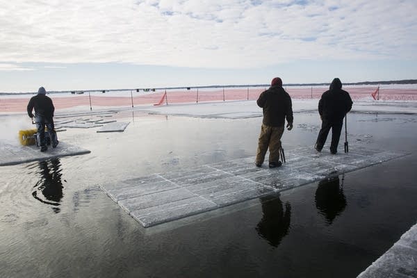 A float of 18 ice blocks  and two Wee Kut Ice workers drifts in Green Lake