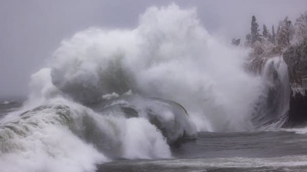 Large waves crash against the cliffs