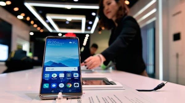 A Huawei representative prepares a Huawei smartphone for display during the 2018 International Consumer Eleectronics Show at the Las Vegas Convention Center.