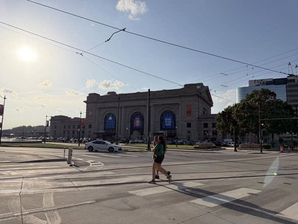 A woman crosses the street beneath streetcar wires near Kansas City's Union Station.