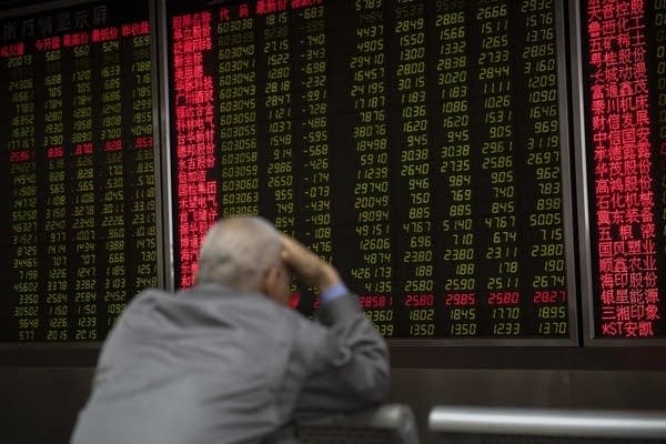 An investor looks at stock price movements on a screen at a securities company in Beijing on May 6, 2019. - China's key stock indices plunged more five percent on May 6 after US President Donald Trump threatened to hike tariffs on Chinese imports, potentially derailing high-level trade talks as they enter their final phase.