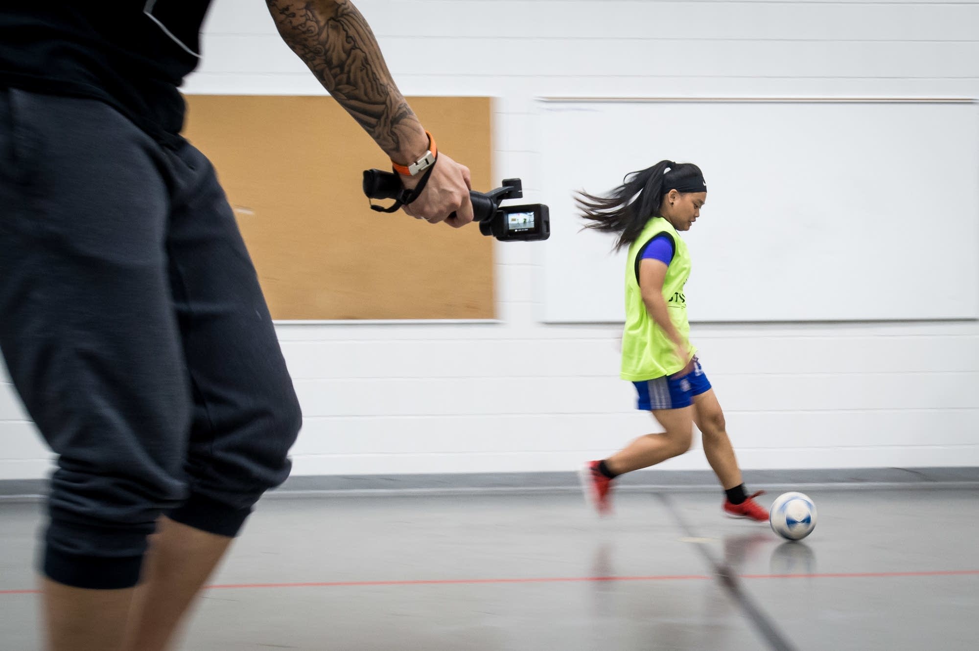 Coach Kyle Johnson films Hser Ku Wah, 15, during futsal practice.