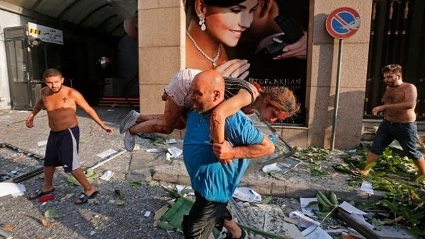 A man carries away an injured girl in Beirut, Lebanon.