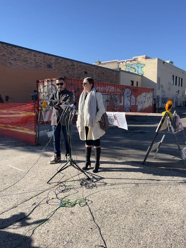two people talk at a microphone 