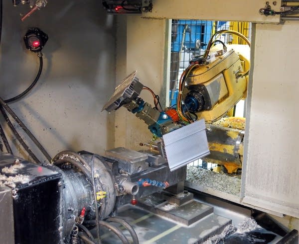 A robot loaded a part into a milling machine.