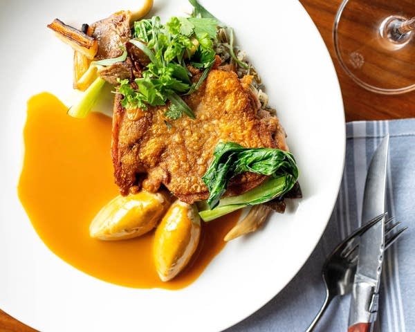 Overhead shot of a white plate with fried chicken breast and a brown sauce.