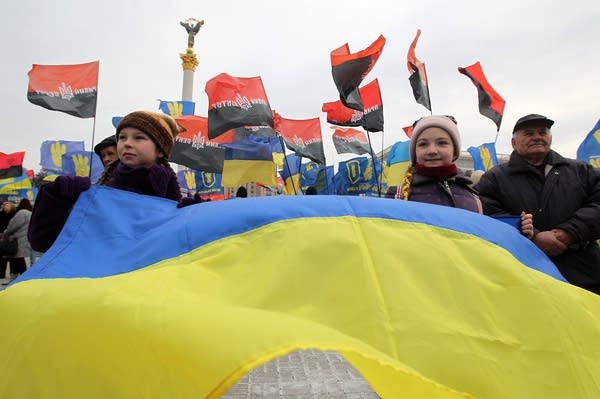 Ukrainian activists from different nationalist parties hold posters and flags as they take part at a rally in February. (Photo by STR/NurPhoto via Getty Images)