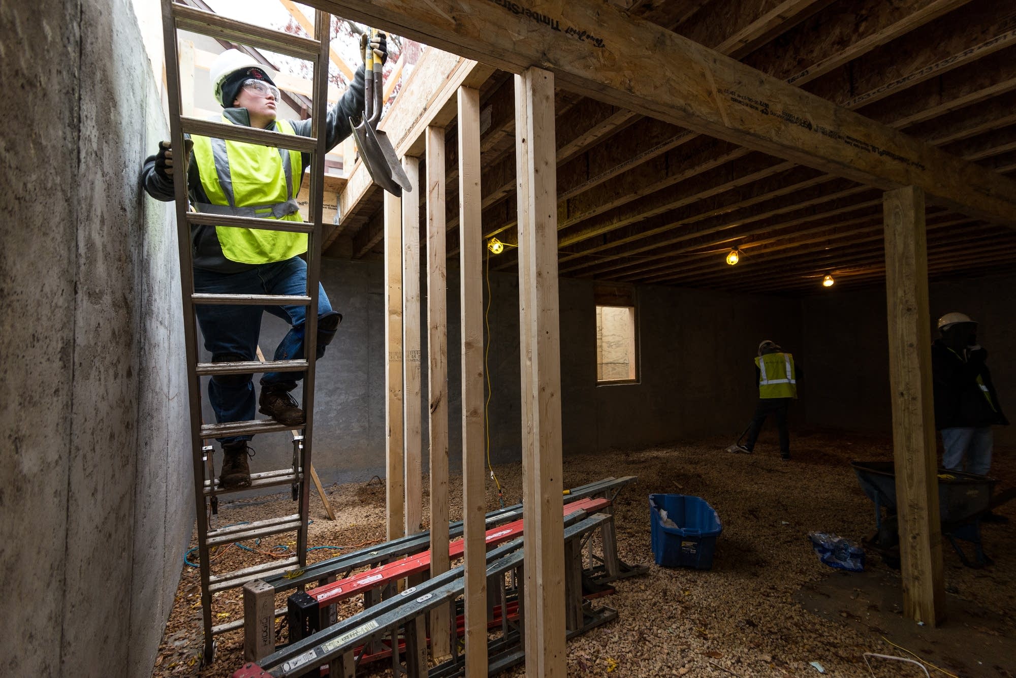 Carl Tomlinson, 17, brings shovels down into the basement.