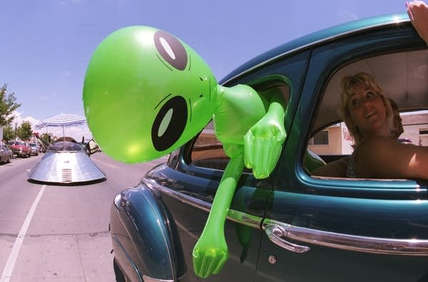 An alien doll hangs out a car window in downtown Roswell, New Mexico, on July 1, 2000.