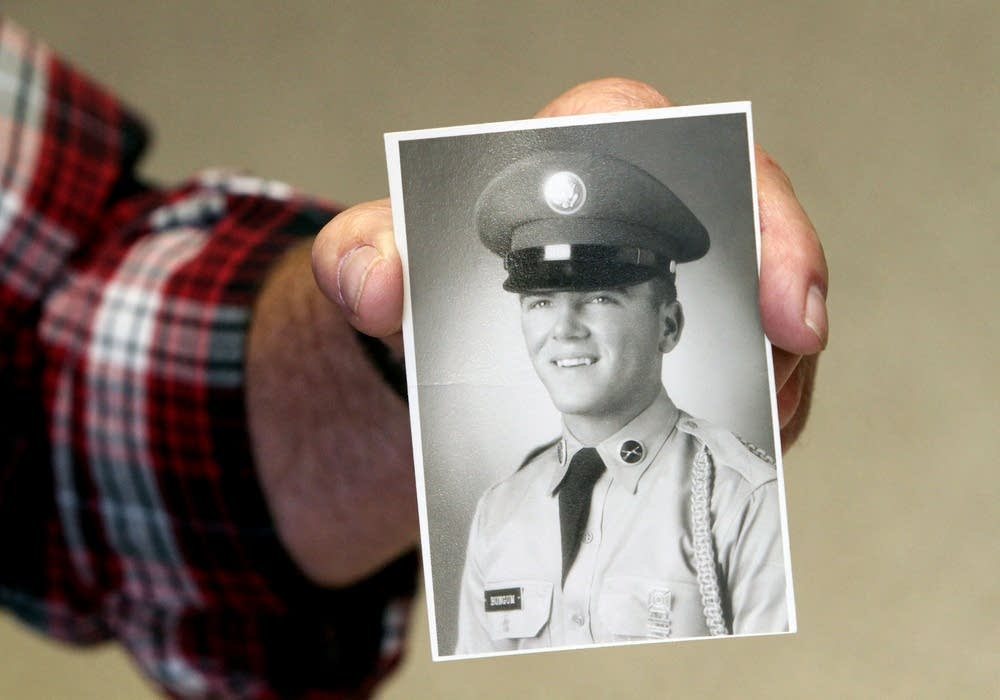 Galen Bungum holds an old photo of himself.