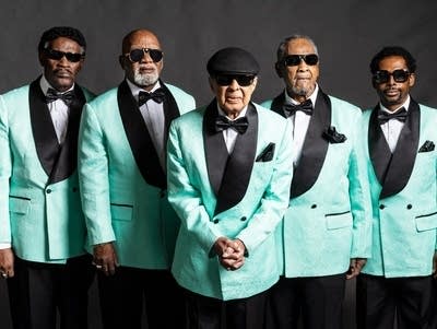 Five men in suits and sunglasses pose for a portrait