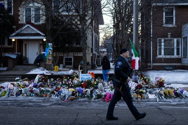 An officer walks past a memorial