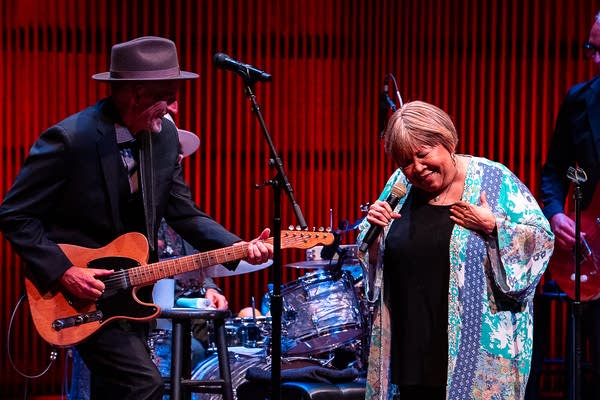 Two musicians performing together onstage in a concert hall
