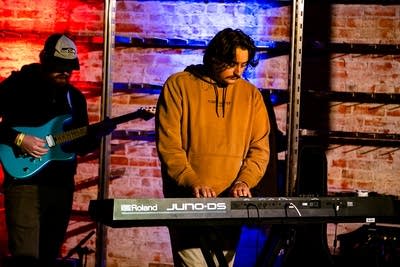 Two musicians perform together onstage