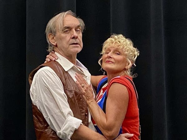 A man and woman embrace on stage for a production of Sweeney Todd.