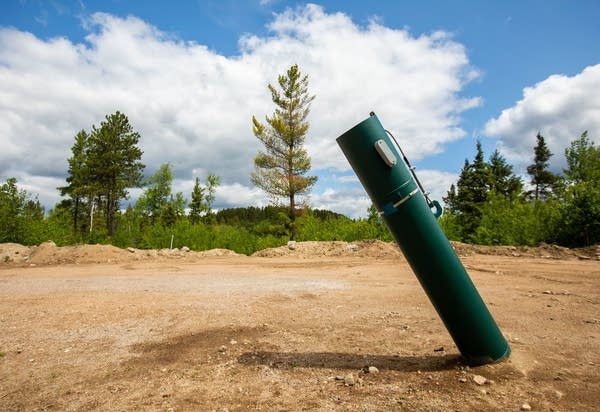 A hydro well sits in a cleared out area of forest.