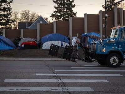 A truck drives past a row of tents