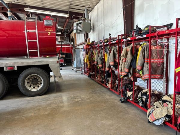 Gear sits behind a truck in racks along a wall.