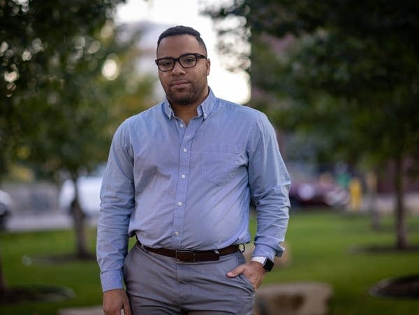 A man with glasses poses for a portrait