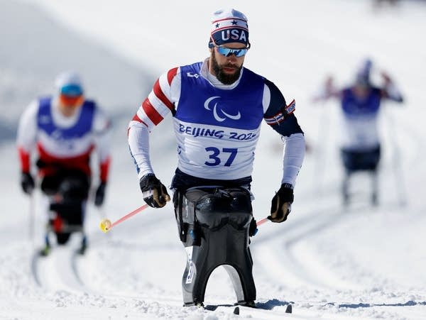 An athlete pushes forward with ski poles