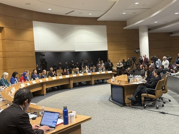 A hearing is held in a meeting room.