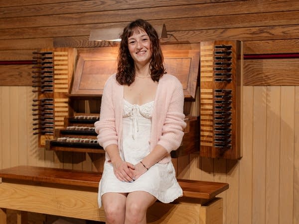 Poster Agnes Barthel wears a dress and sits at an organ.