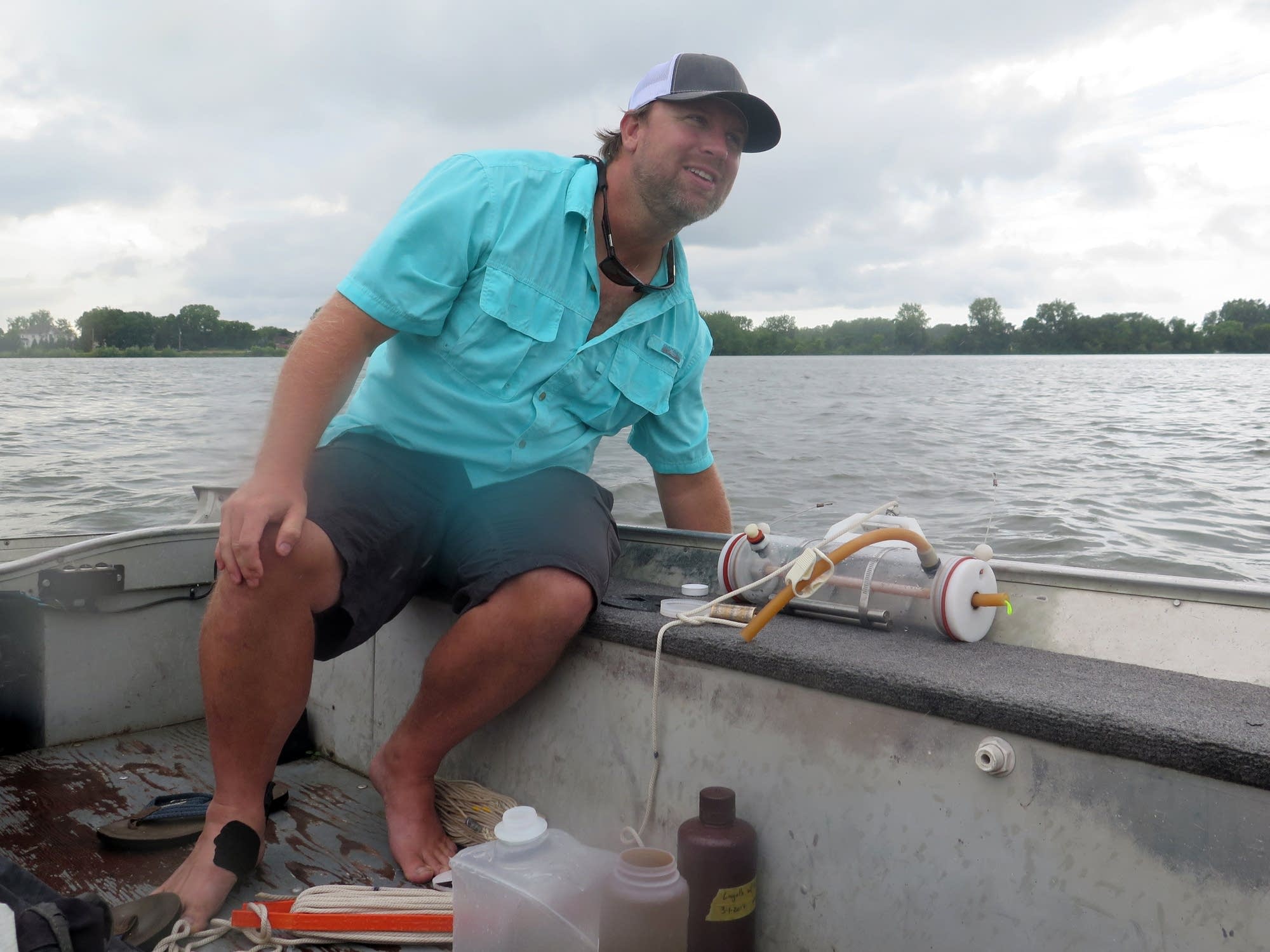 UMD researcher Andy Bramburger collects a water sample from Peltier Lake.