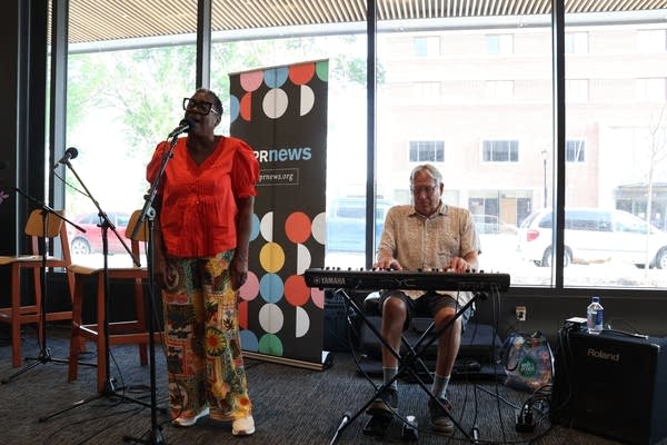 Two musicians perform on a stage in the Moorhead Public Library.
