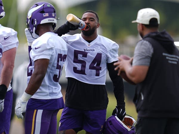 A man hydrates during a camp