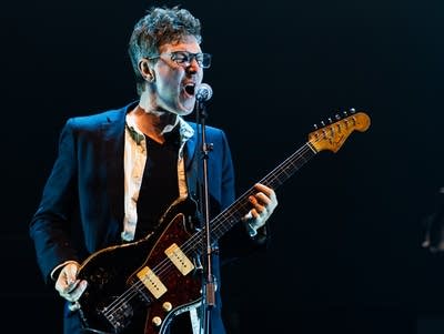 Hamilton Leithauser sings into a microphone and plays an electric guitar at Armory.