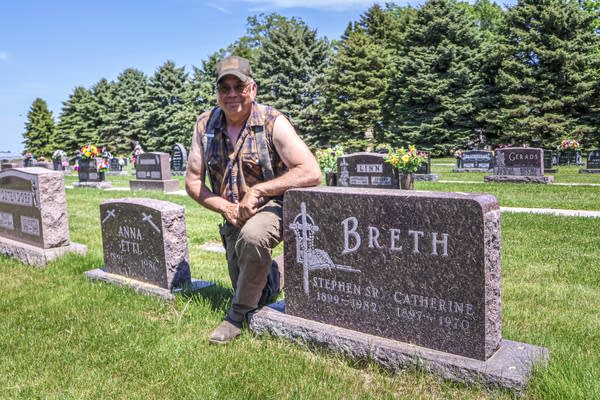 Jerry Breth kneels by the grave