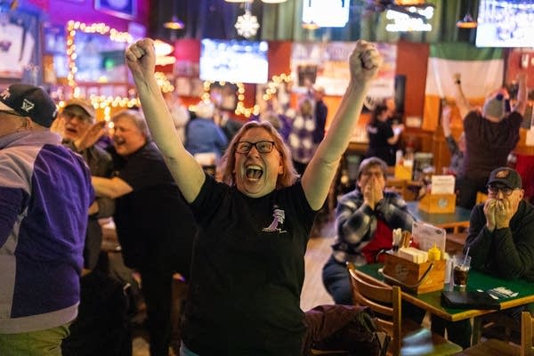 A woman cheers in a bar