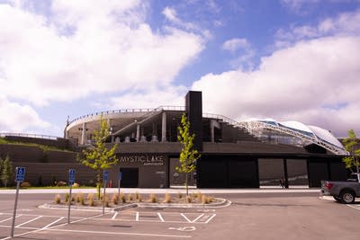 An outdoor amphitheater with a stage under a partial roof.