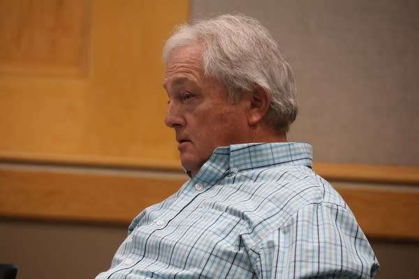 A man leans back in a chair.
