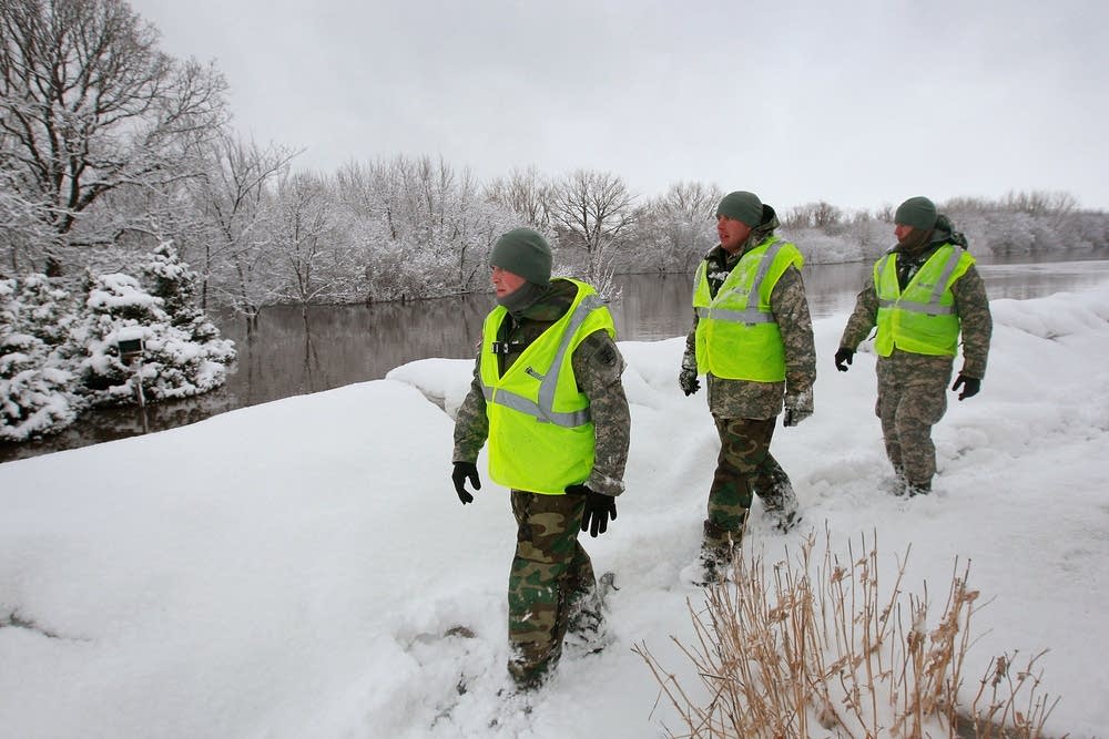 Guard members inspect a levee