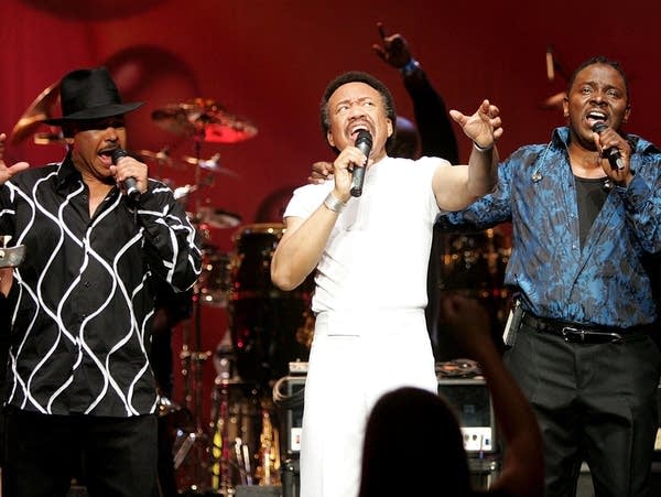 Maurice White flanked by singers Ralph Johnson (left) and Philip Bailey (right) of the band Earth, Wind & Fire perform at the Wiltern Theater December 11, 2004 in Los Angeles.