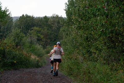 Two people run down a hill