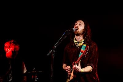 A musician sings and plays guitar onstage