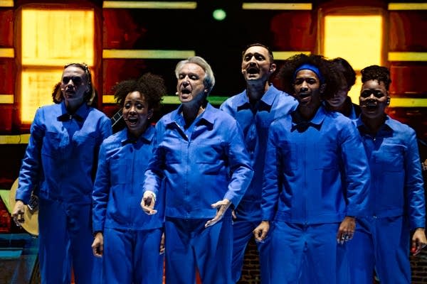 David Byrne and band performing on stage