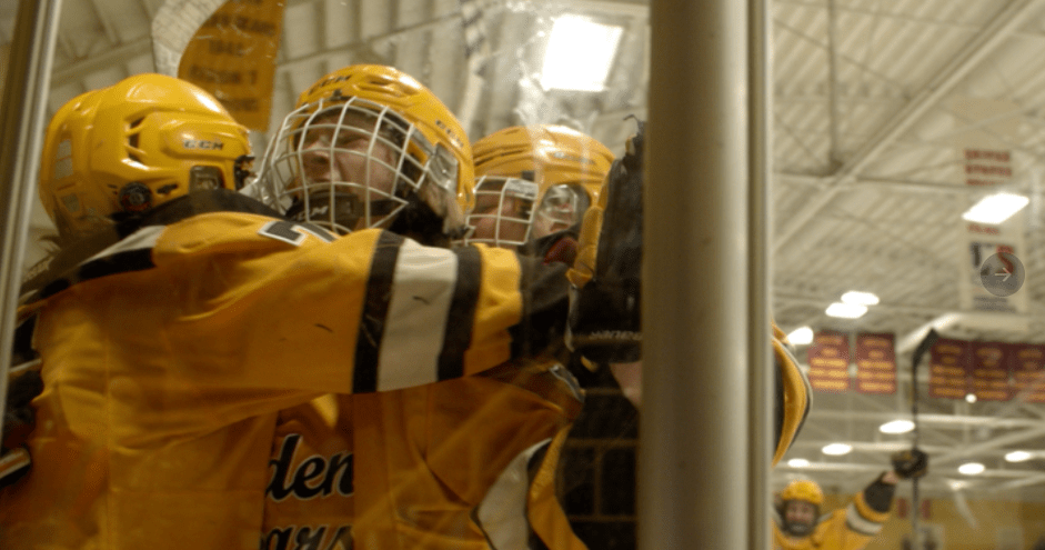 People in hockey gear wait to go on the ice