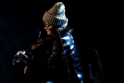 A musician plays violin onstage in a music venue