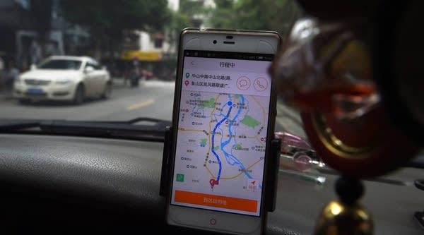 A taxi driver uses the Didi Chuxing app while driving along a street in Guilin, in China's southern Guangxi region.