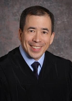 man smiling in headshot with judge gown