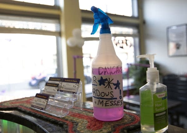 A bottle of disinfectant and hand sanitizer on a counter. 