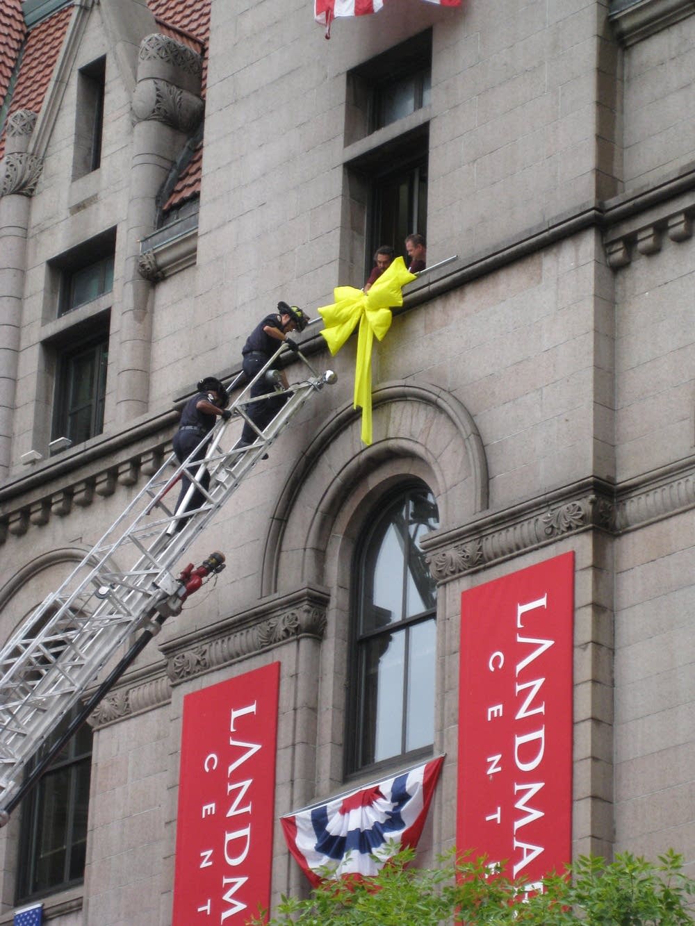 Firefighters hang a ribbon on the Landmark Center